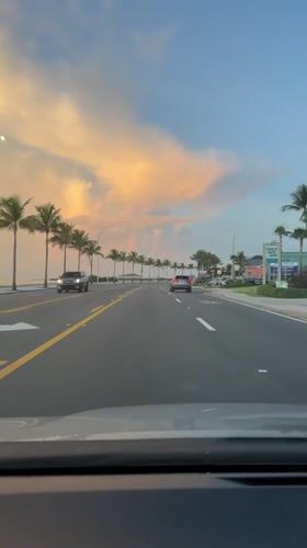 Cruising a palm-lined Key West road under a colorful sky