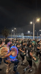 Costumed dancers perform at nighttime street festival in Arica