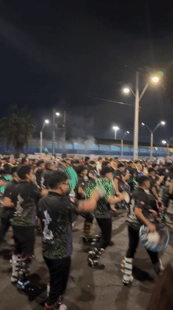 Costumed dancers perform at nighttime street festival in Arica