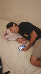 Man photographed laughing on bed in Tinaquillo, Venezuela