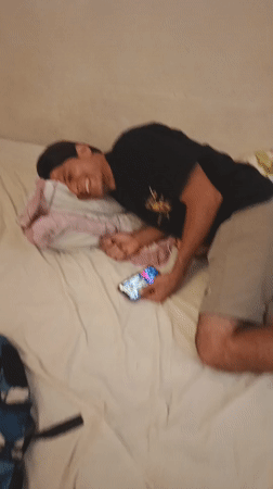 Man photographed laughing on bed in Tinaquillo, Venezuela