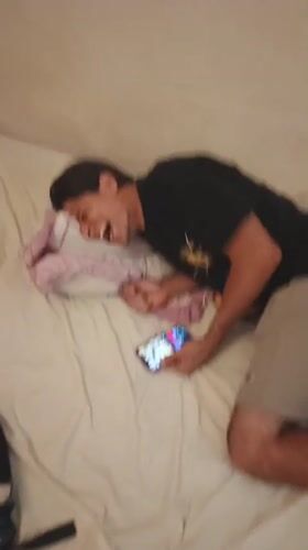 Man photographed laughing on bed in Tinaquillo, Venezuela