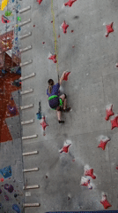 Woman rock climbs at indoor facility in Krasnoyarsk
