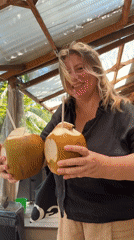 Woman enjoys coconuts at beachside café in Đà Nẵng