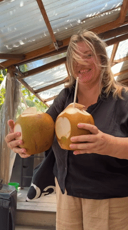 Woman enjoys coconuts at beachside café in Đà Nẵng