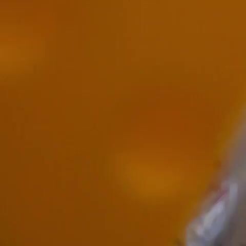 A camera pans up to reveal a beer can. In the background is a glass candle jar with a portrait of Jesus on its label. The label reads "Perfumada / Perfumed." Other cans and glasses are in the background as well.