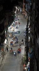 Nighttime street activity captured in busy Dhaka neighborhood