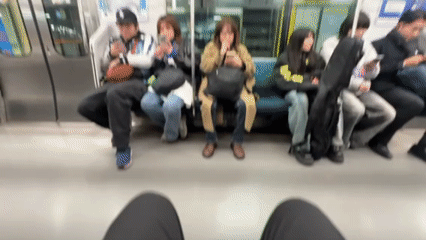 Commuters use phones on Tokyo subway during Saturday morning