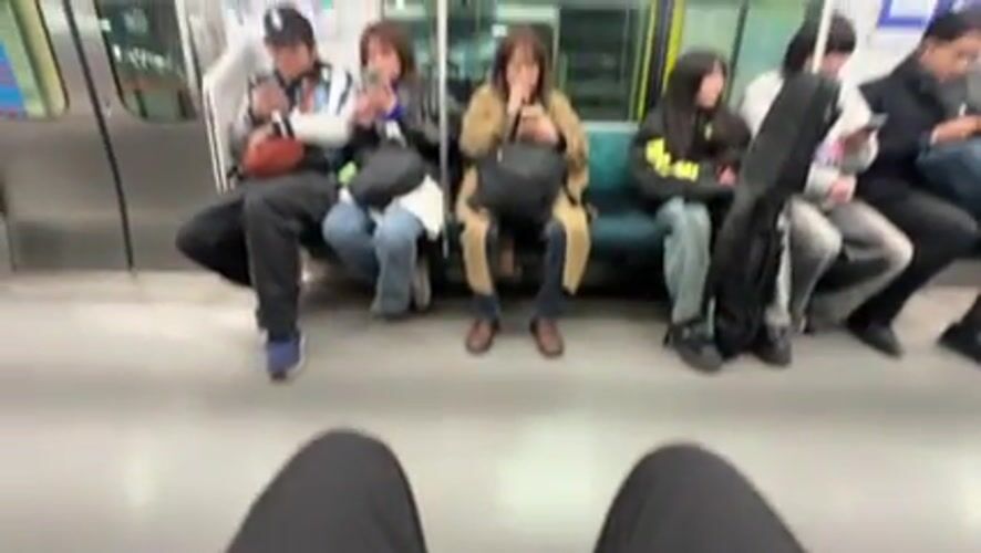 Commuters use phones on Tokyo subway during Saturday morning