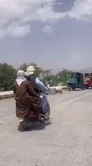 Children ride in truck bed with adult supervisor in Quetta