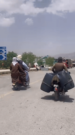 Children ride in truck bed with adult supervisor in Quetta
