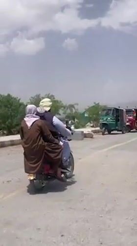 Children ride in truck bed with adult supervisor in Quetta