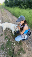 Woman walks dog, picks wildflowers on Bulgarian countryside paths