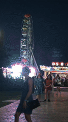 Blue-lit Eiffel Tower replica at a nighttime amusement park