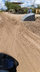 Motorcyclists navigate construction zone on Dar es Salaam dirt road