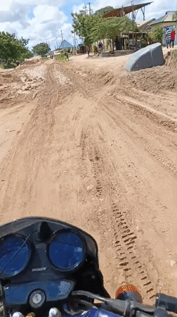 Motorcyclists navigate construction zone on Dar es Salaam dirt road