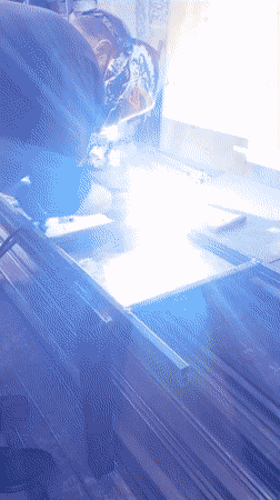 Welder fabricates metal frame at workbench, sparks flying