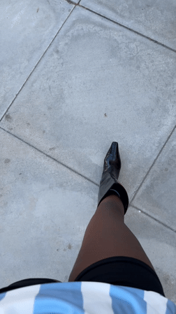 Person films self walking in Palm Desert wearing striped top