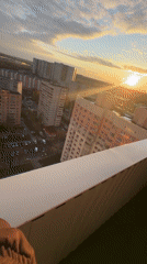 Woman films sunset selfies from Moscow high-rise balcony