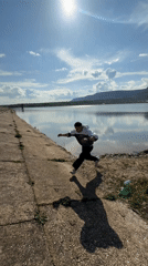 Man reaches toward splashing water near concrete structure in Bulgaria