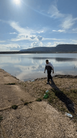 Man reaches toward splashing water near concrete structure in Bulgaria