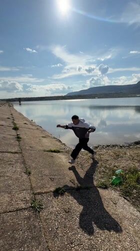 Man reaches toward splashing water near concrete structure in Bulgaria