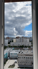 Dramatic stormy skies captured over urban landscape from window