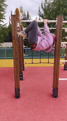 Girl plays at playground, rides pink bicycle during spring morning