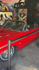 Red convertible parked inside a graffiti-covered El Paso venue