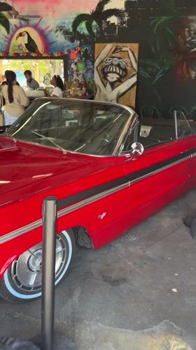 Red convertible parked inside a graffiti-covered El Paso venue