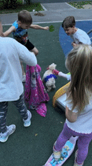 Children play with colorfully-dyed dog in Moscow park