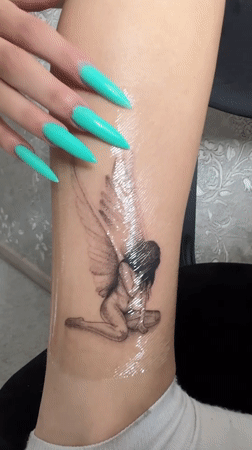 Fresh winged woman ankle tattoo documented in Abakan