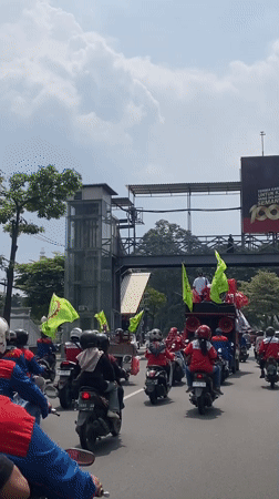 Motorcycle procession with decorated vehicles parades through Surabaya streets