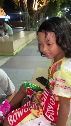 Father helps daughter learn roller skating at Indonesian park