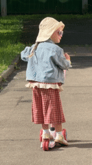 Child rides scooter on Moscow path wearing colorful outfit