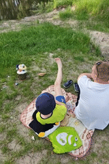 Father and son enjoy lakeside picnic in Hadiach, Ukraine
