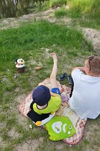 Father and son enjoy lakeside picnic in Hadiach, Ukraine