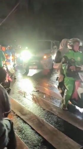 Night traffic moves through flooded Depok streets after rainfall