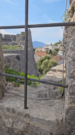 Stone fortress in Herceg Novi, framed by climbing vines