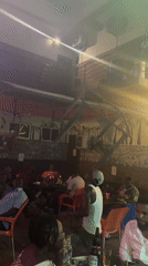 Man dances at bar while patrons socialize in Ado