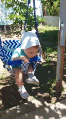 Child plays in backyard garden swing in Tavaksay