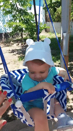 Child plays in backyard garden swing in Tavaksay