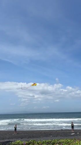 Kite flying on black sand beach in Blahbatuh, Indonesia