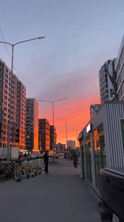 Dramatic sunset colors illuminate Kudrovo residential district at twilight