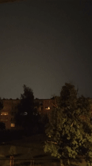 Bright flash of light near an apartment building at night