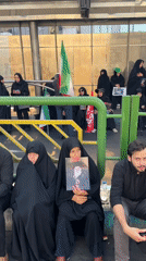 Crowd with Iranian flag gathers behind barrier in Tehran