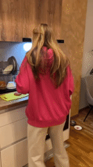 Woman cooks meatball dinner with cat in Montenegro kitchen
