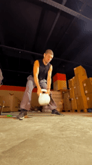 Kettlebell training in a dim warehouse gym, Karaganda