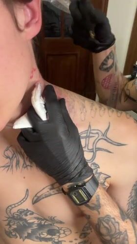Tattoo artist works on client's neck in Buenos Aires