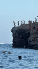 Cliff jumping off the rocky Budva coastline, Montenegro